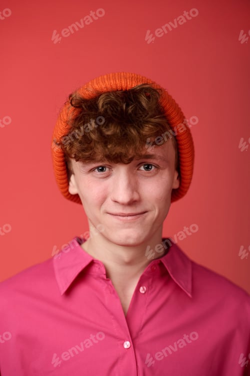 Preview: Portrait of Smiling Young Man Wearing Orange Beanie and Pink Shirt