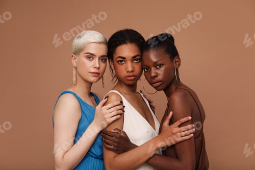 Preview: Three diverse women looking at camera. Young females with different skin tones standing together.