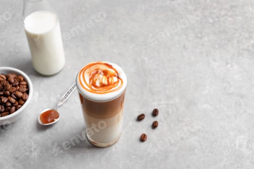 Preview: Glass with delicious caramel latte on table