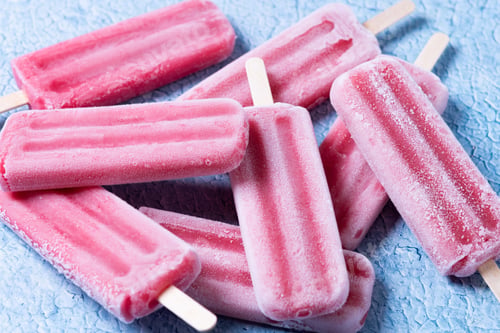 Preview: Red strawberry popsicles on blue background.