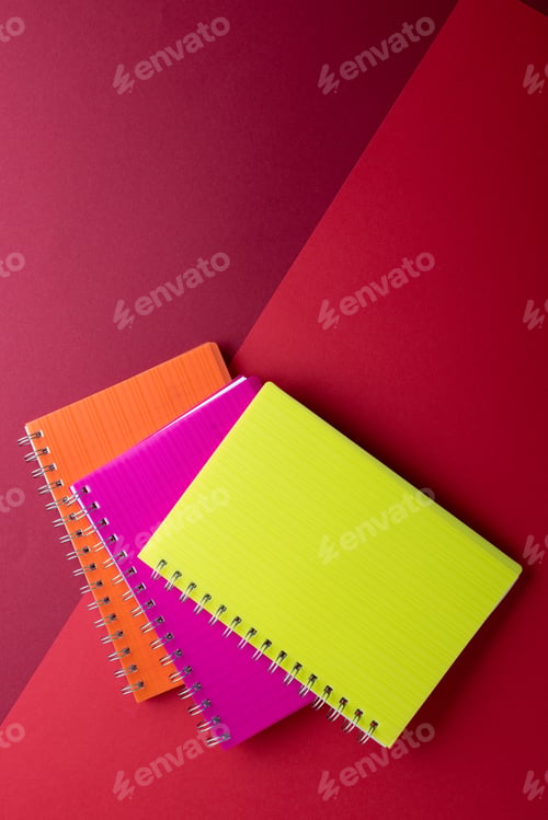 Preview: Three notebooks with binding and copy space on red background