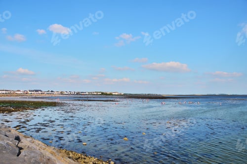 Preview: View at beach full of people in sunny summer day. Blue sky with couple clouds and calm ocean