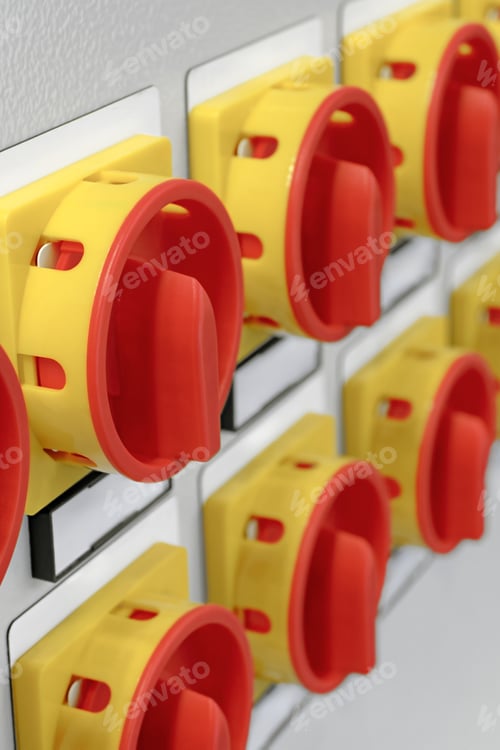 Preview: A lot of red and yellow electric switches with white labels on a grey control panel
