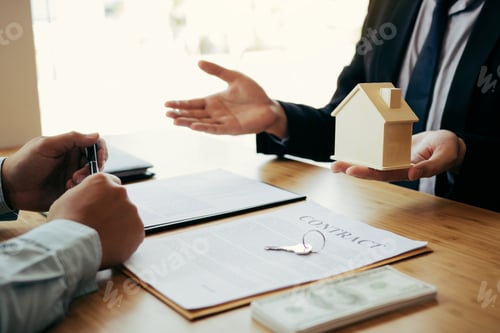 Preview: Real estate agent congratulations to new buyer by giving house model to client in the agency office.