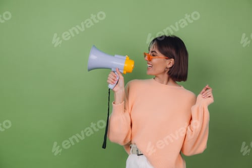Preview: Smiling Young Woman with Megaphone in Green Studio