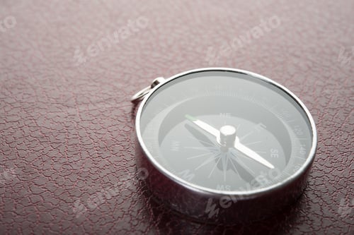 Preview: Compass over on red leather background. Travel concept.