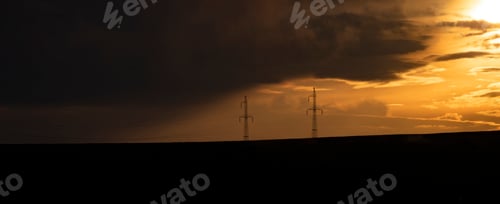 Preview: Silhouette of high voltage electric tower on sunset time.