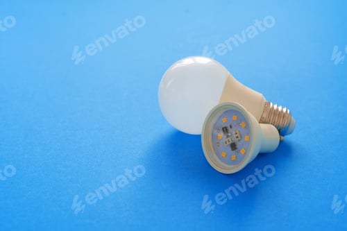 Preview: Light bulbs on blue paper background close up