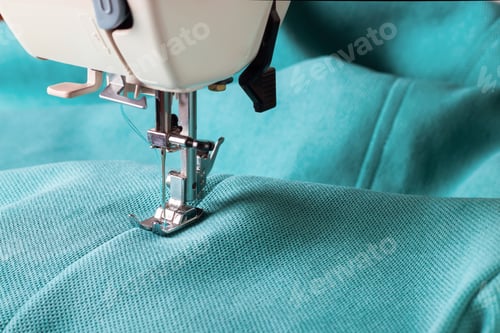 Preview: Close up of sewing machine working with turquoise fabric