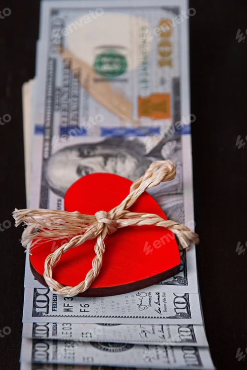 Preview: bundle of American one hundred dollars with a red heart tied with a natural rope with bow