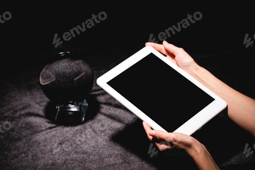 Preview: cropped view of astrologer holding digital tablet near crystal ball on black velvet cloth