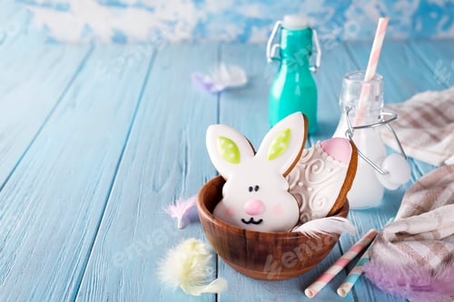 Preview: Easter cookies as rabbit and egg in the wooden bowl with milk in glass on wood background