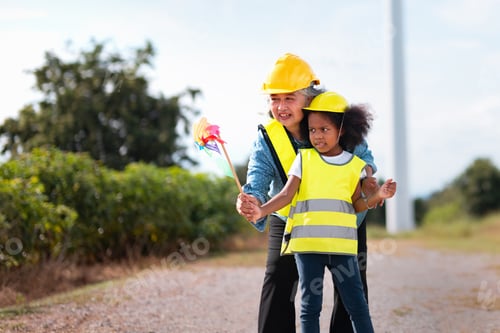 Preview: woman and child are standing on road, with the woman holding kite