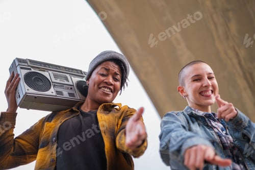 Preview: Friends with an urban style but with different origins singing and dancing outdoors at sunset.
