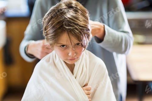 Preview: A six year old boy getting his hair cut at home by his mother
