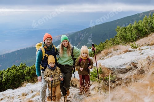 Preview: Happy family hiking together in autumn mountains.