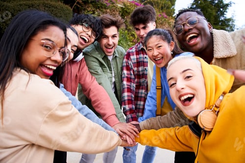 Preview: Cheerful multiracial group of students making pile hands and smiling at the camera on campus.