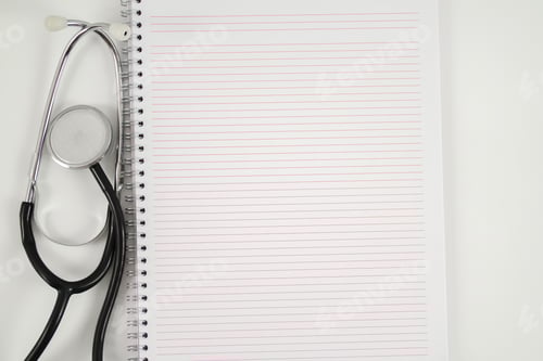 Preview: Stethoscope and empty note book laying close together on the white background.