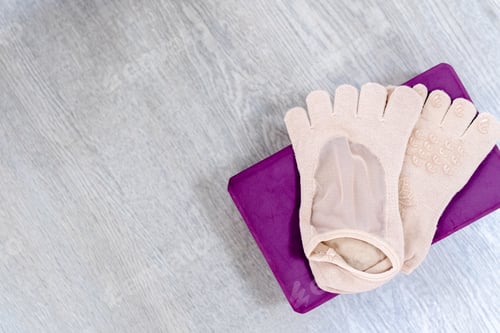 Preview: Close up yoga socks on purple yoga blocks. Copy space