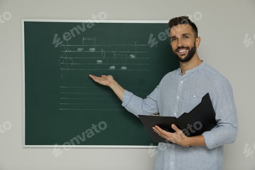 Preview: Teacher near green chalkboard with music notes in classroom
