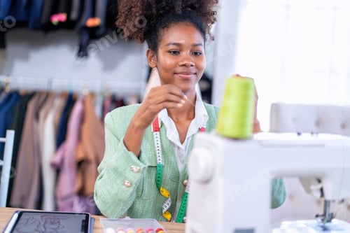 Preview: Stylish fashionable clothes designer girl at a sewing machine design clothes tailoring studio room