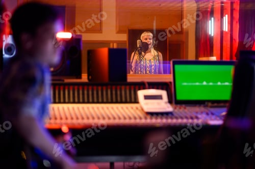 Preview: Young caucasian female singer singing in a music studio and recording a new song