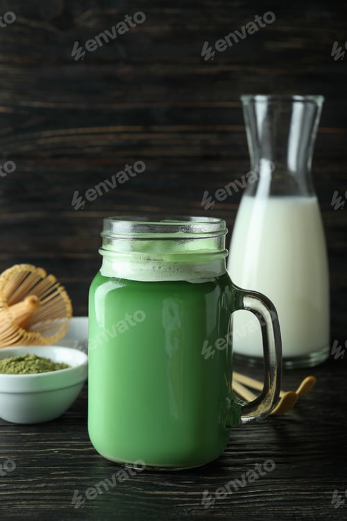 Preview: Glass jar of matcha latte and accessories for making on wooden background