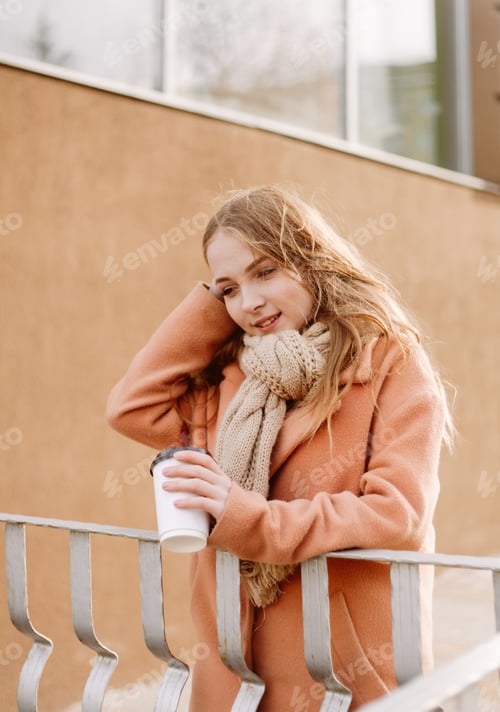 Preview: Young Woman Leaning on Railing with Coffee Cup