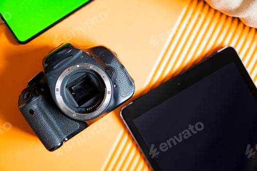 Preview: SLR camera and tablet on orange surface