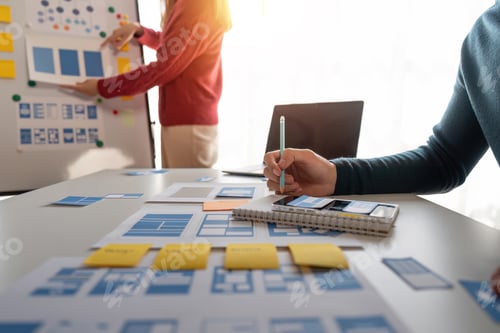 Preview: Close up ux developer and ui designer brainstorming about mobile app interface wireframe design at