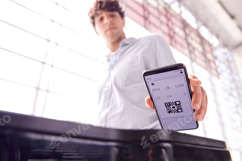 Preview: Male Passenger In Airport Departure Lounge Scanning Digital Boarding Pass On Smart Phone