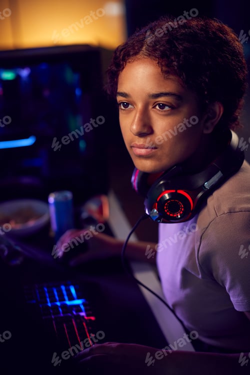 Preview: Teenage Girl With Headset Gaming At Home Using Dual Computer Screens