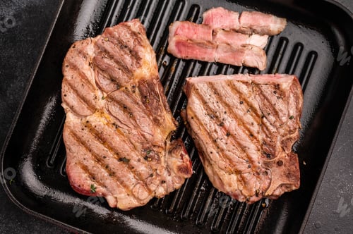 Preview: Fried on grill skillet pork tender steak, neck meat. black background. top view