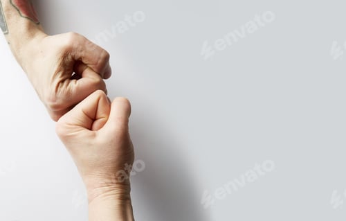 Preview: Close up clash of two fists on white blank background. Concept of confrontation, competition etc.