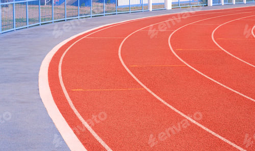 Preview: Empty red curve synthetic running tracks with pavement and fence in athletic outdoors stadium