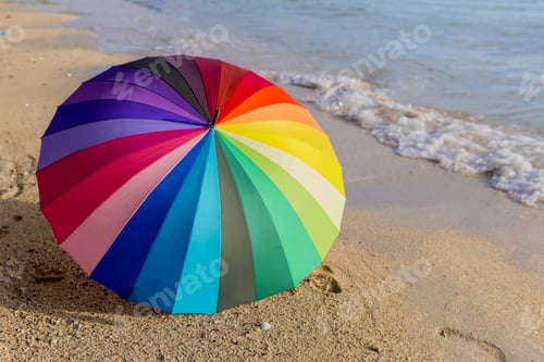 Preview: Rainbow color of umbrella on white sand beach.