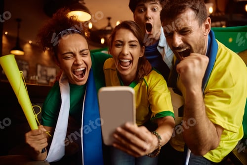 Preview: Group of sport fans shouting while using cell phone and cheering for their favorite team.