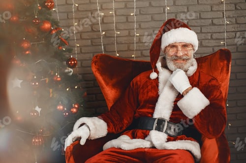 Preview: Man in santa claus costume sitting on a chair
