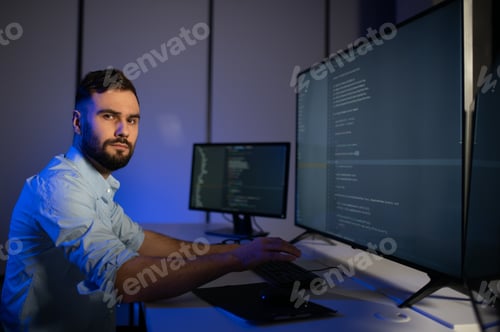 Preview: Portrait of male programmer in office at night