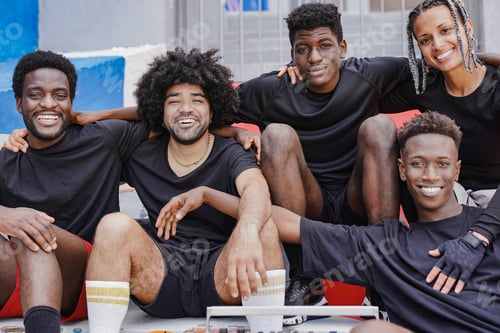 Preview: Group of multiethnic friends having fun together in the city after basketball match