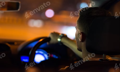 Preview: The man drive a car in the night city. Left side traffic