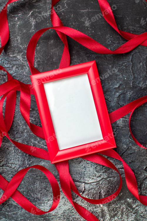 Preview: Above view of red and white picture frames ribbon on icy dark background