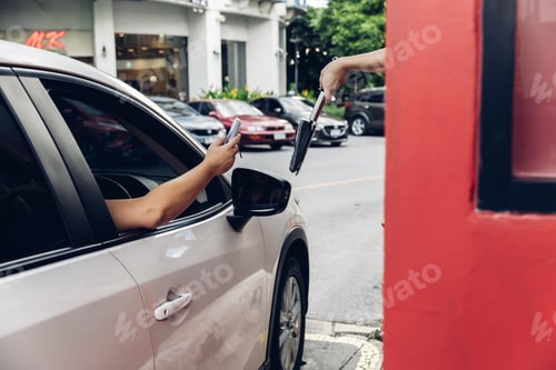 Preview: Hand Man in car receiving coffee in drive thru fast food restaurant.