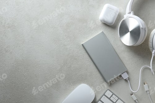 Preview: Powerbank and headphones on gray background, space for text
