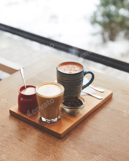 Preview: Hot coffee with milk in table in coffee shop