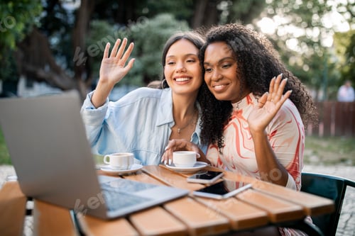 Preview: Two Happy Female Friends Making Video Call On Laptop Outdoors At Cafe