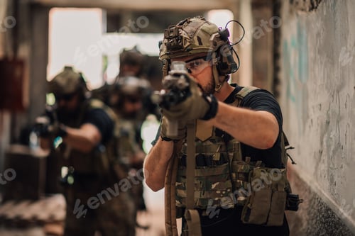 Preview: Portrait of air soft warrior standing in ruins and shooting towards camera