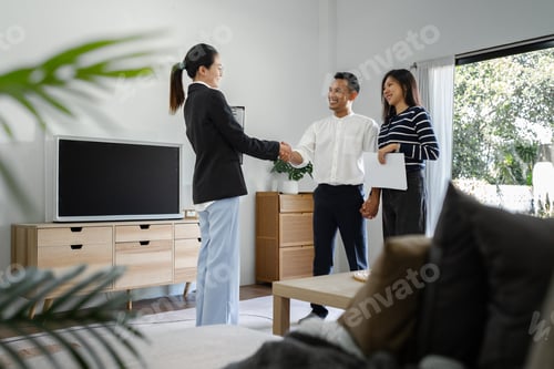 Preview: Young happy smiling couple read agreement with realtor and looking through the contract of real