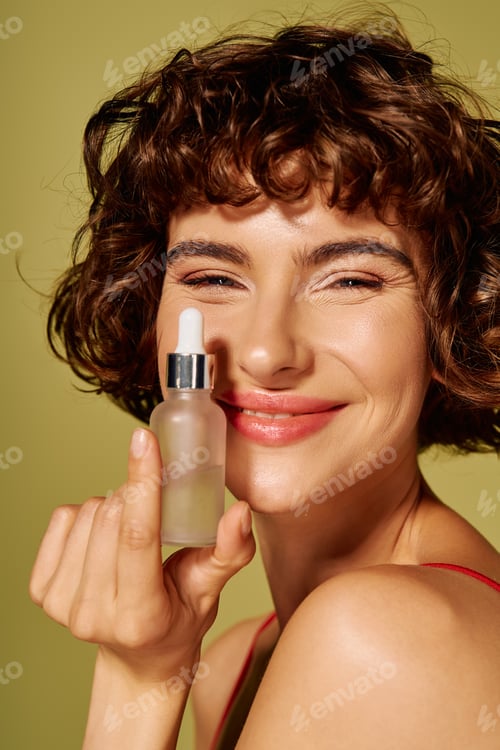 Preview: A young woman joyfully showcasing her favorite skincare serum against a vibrant backdrop