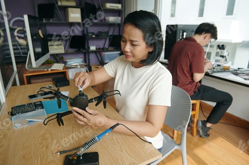 Preview: Woman Repairing Broken Drone In Workshop